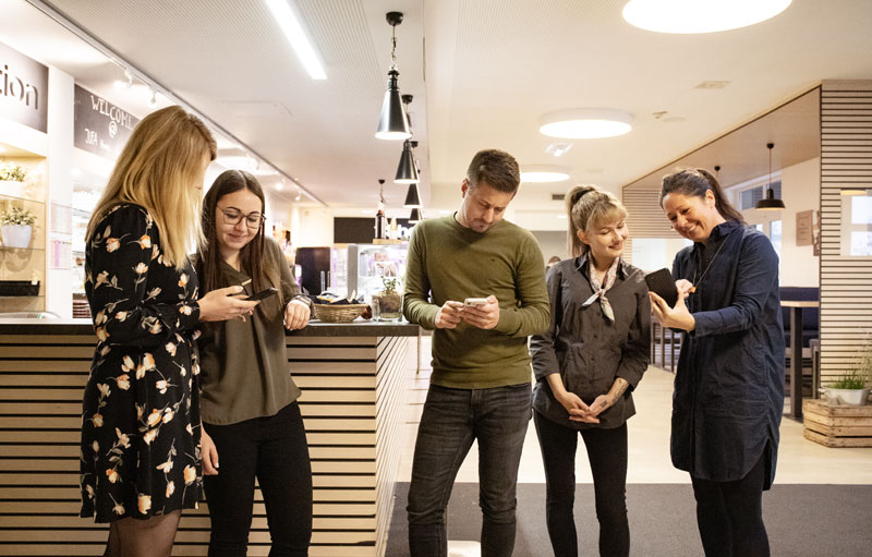 JUFA Mitarbeitende mit der JUFA App, dem neuen mobilen Social Intranet von LOLYO Gruppi di persone alla reception utilizza l'intranet mobile app di lolyo e studia le varie funzioni con soddisfazione